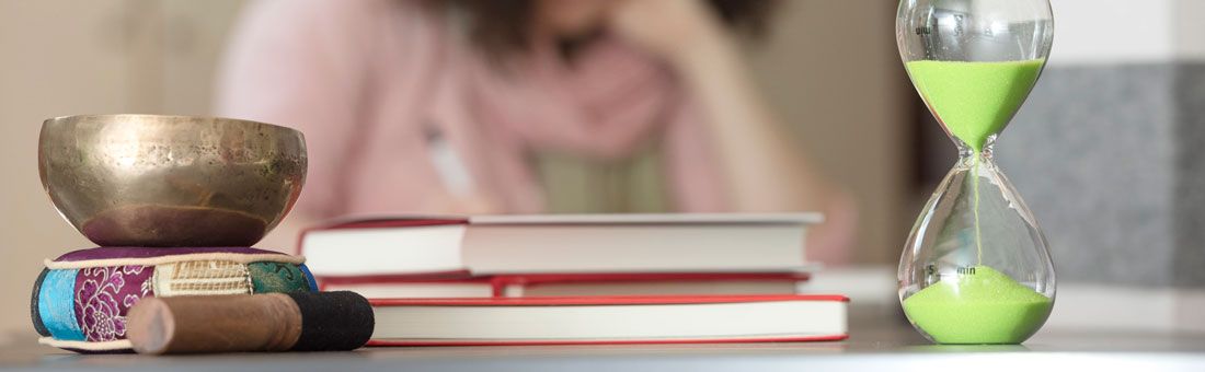 Klangschale, Sanduhr und Bücher